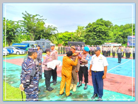 Pj. Bupati Rote Ndao Oder Maks Sombu, SH,MA,MH melakukan penyematan pita tanda operasi kepada perwakilan peserta Apel Gelar Pasukan Operasi Kepolisian Terpusat Ketupat Turangga 2024