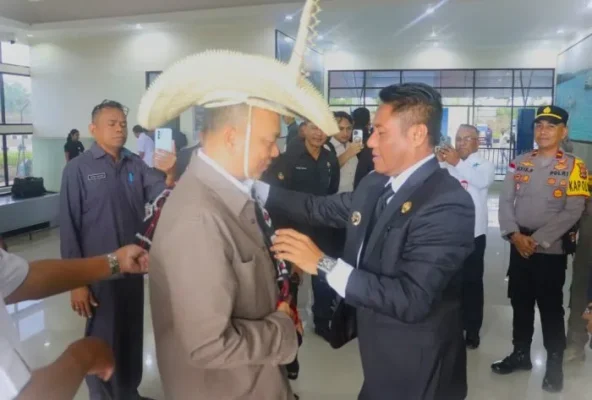 Bupati Rote Ndao Paulus Henuk, SH mengenakan Topi Ti’i Langga dan Selimut kepada Dirjen PK Kemneterian Kelautan dan Perikanan Ir. Koswara, MP.