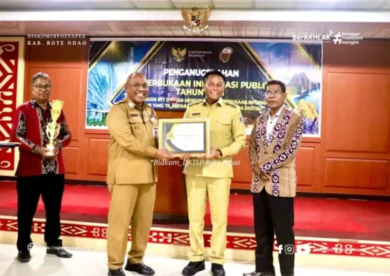 Asisten Administrasi Umum Setda Provinsi NTT Semuel Halundaka, S.IP,M.Si menyerahkan Penghargaan Keterbukaan Informasi Publik kepada Bupati Rote Ndao Paulus Henuk, SH.