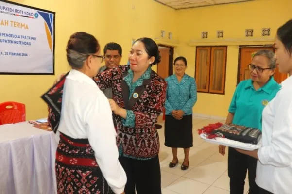 Pengalungan Selempang : Ketua TP PKK Rote Ndao Yanne Henuk-Pellokila mengalungkan selempang kepala Sip Efrida Serah Kepala TPA yang lama dalam acara Sertijab.