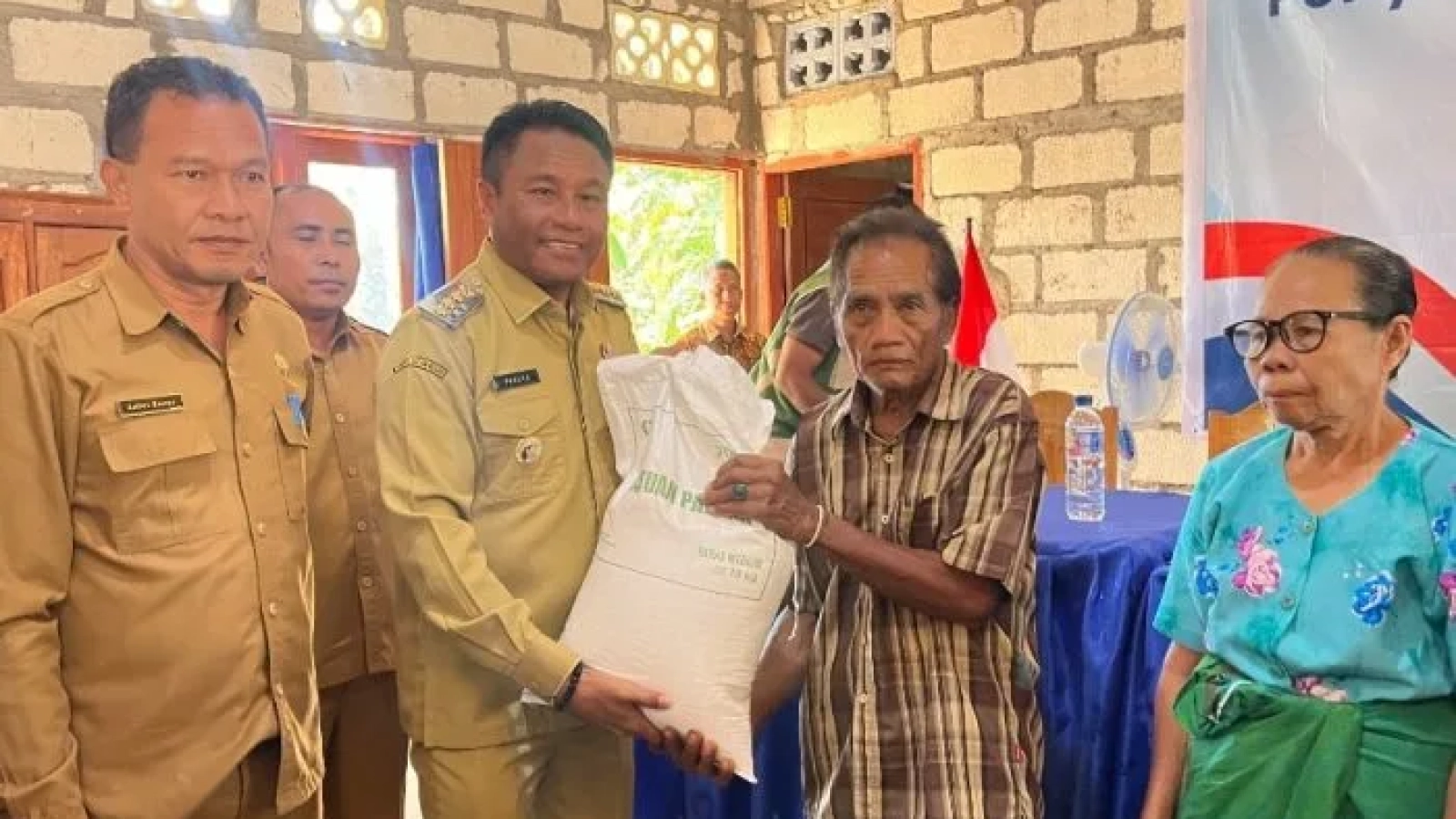 Bupati Paulus Henuk saat menyerahkan secara simbolis penyaluran pangan beras kepada salah seorang warga.