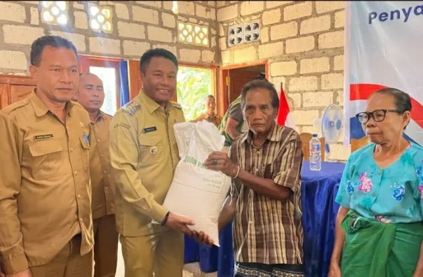 Bupati Paulus Henuk saat menyerahkan secara simbolis penyaluran pangan beras kepada salah seorang warga.