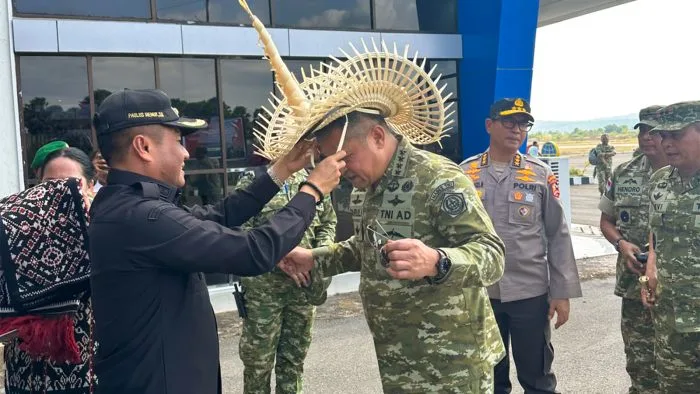 Bupati Rote Ndao Paulus Henuk, S.H., memakaikan topi adat Ti’i Langga kepada Kepala Badan Nasional Pengelola Perbatasan dan Daerah Tertinggal (BNPPTD) RI, Jenderal Maruli Simanjuntak, M.Sc., sebagai bentuk penghormatan adat dalam penyambutan kunjungan kerja di Kabupaten Rote Ndao, Sabtu (24/10/2026).